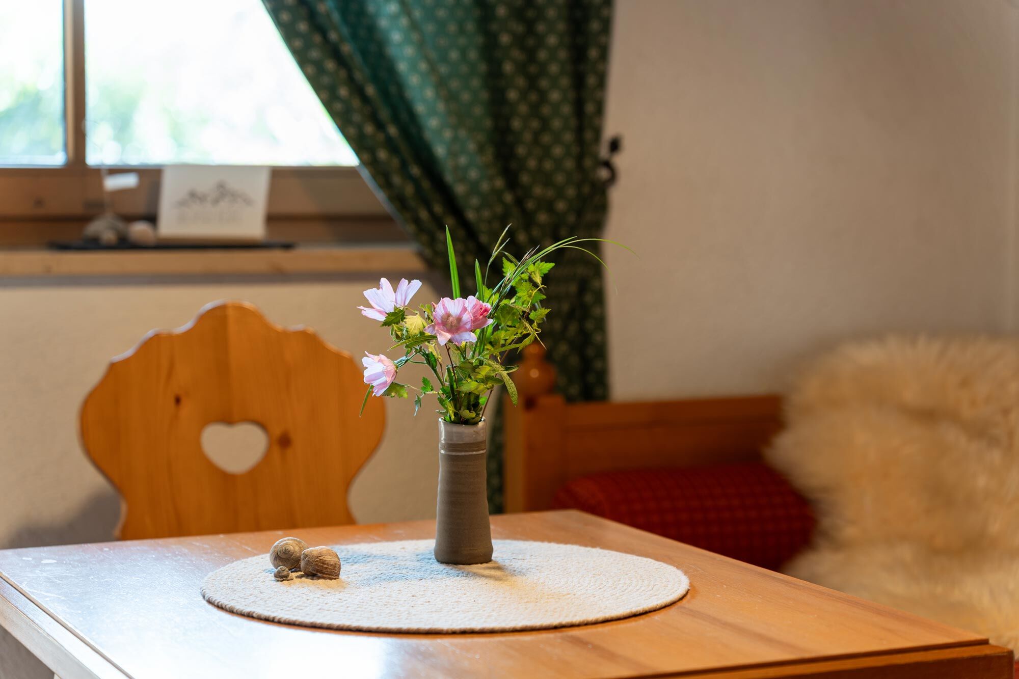 Detailaufnahme einer stilvollen Dekoration aus Holz und Blumen in der Ferienwohnung Martin im Allgäu