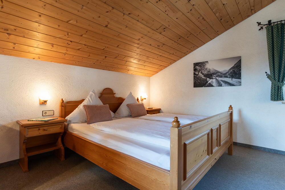Schlafzimmer der Ferienwohnung Martin mit Doppelbett und warmem Holzdesign